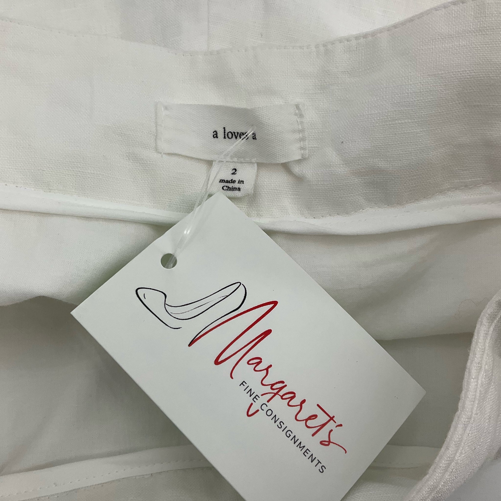 White high-waisted pleated shorts by a loves a, size 2, featuring cuffed hems, perfect for casual coastal wear.