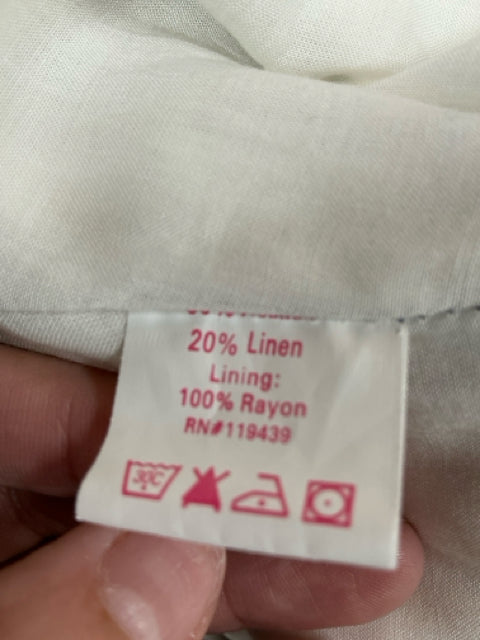 Close-up of fabric content label showing 80% cotton, 20% linen with 100% rayon lining for Julie Brown navy/white striped dress.