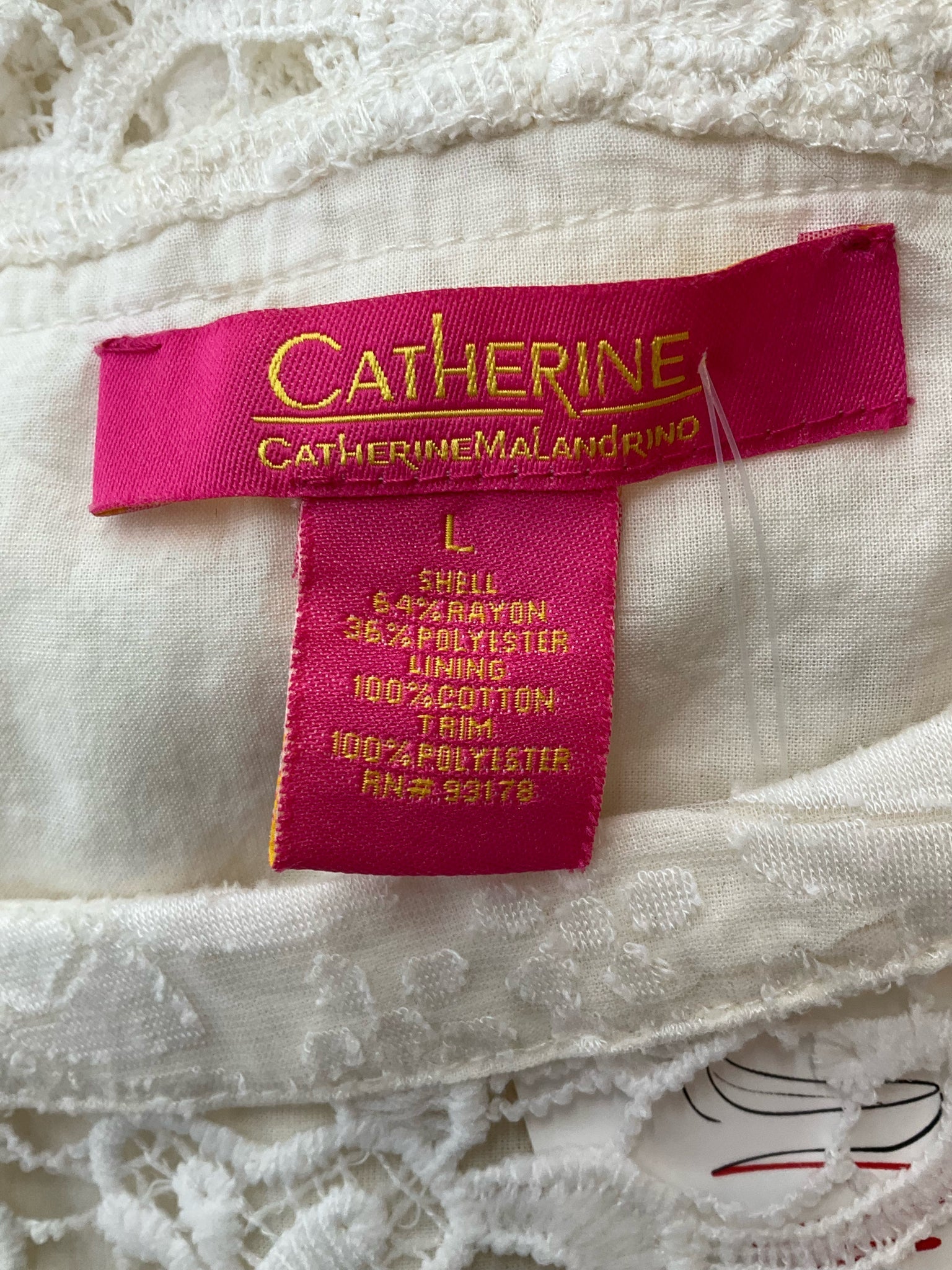 Close-up of Catherine Malandrino dress label showing size large and fabric blend of rayon, polyester, and cotton for sustainable fashion.
