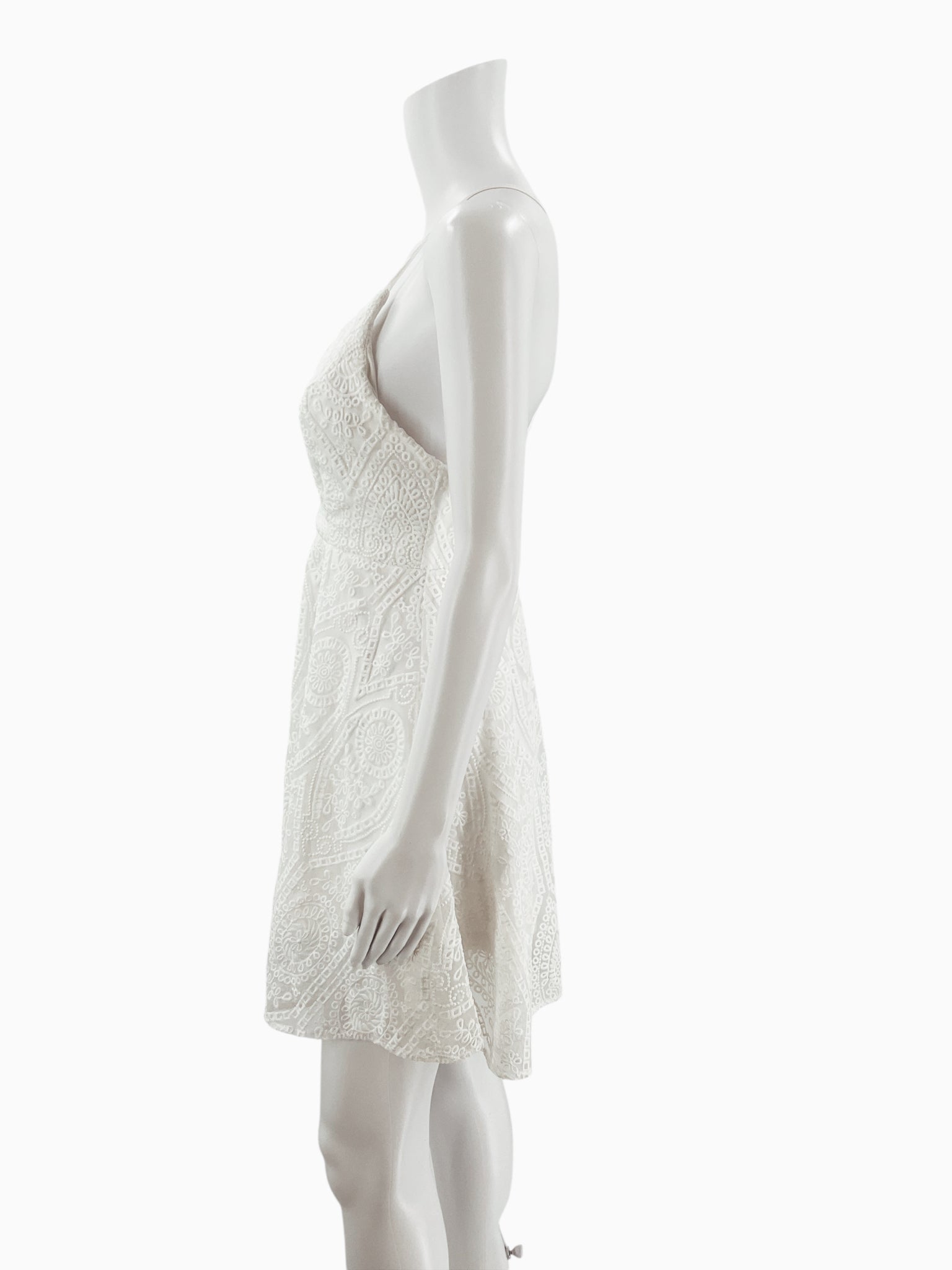 Side profile of Illa Illa white lace A-line mini dress on mannequin, highlighting fitted bodice and flared skirt, size medium.