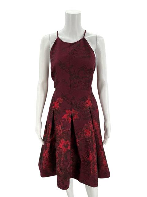 Pre-owned White House Black Market burgundy floral cocktail dress size 10 on mannequin, sleeveless with pleated skirt at Margaret’s Consignments.