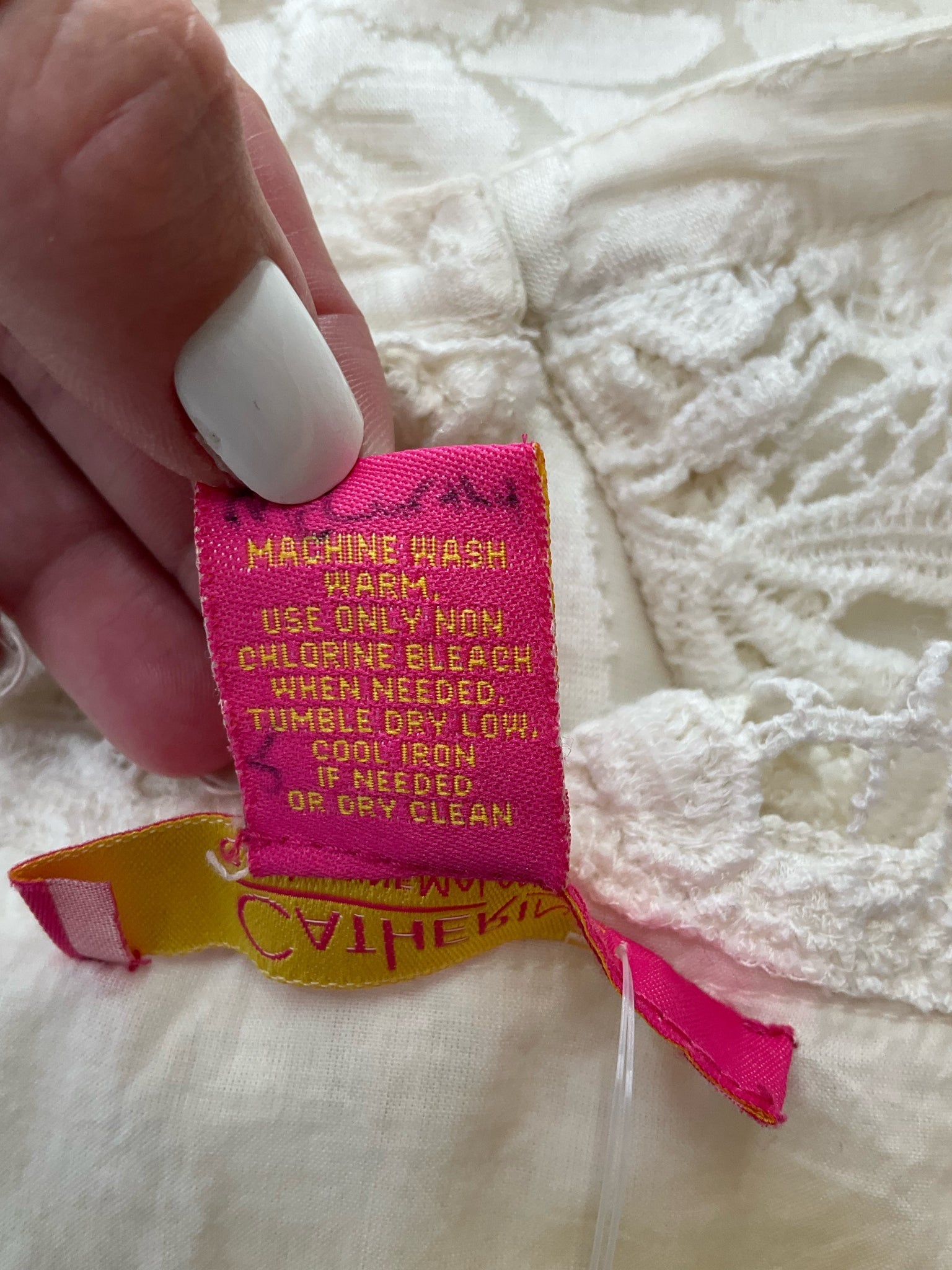 Care label of Catherine Cream Floral Pre-Owned Ladies Dress with washing instructions and fabric details for easy maintenance.