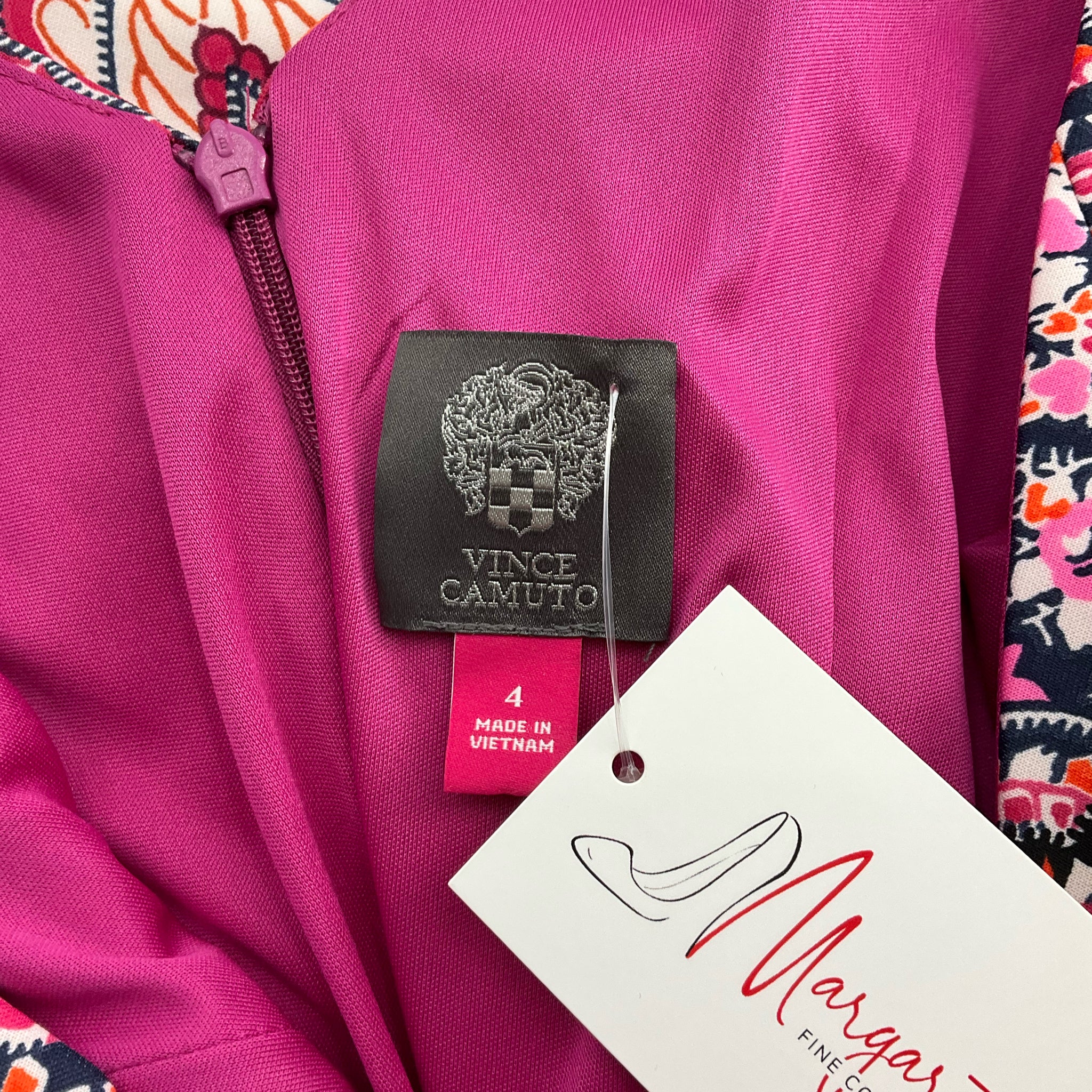 Close-up of Vince Camuto label and size tag on Pink/Navy/Orange Print Dress - Size 4. Pre-owned designer dress available at Margaret’s Fine Consignments.
