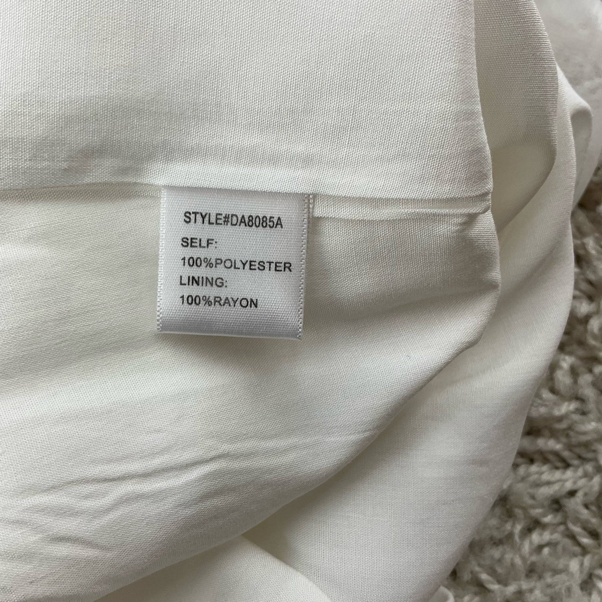 Fabric tag of GB White Sleeveless Mini Dress Size Medium showing 100% polyester shell and 100% rayon lining for breathable comfort.