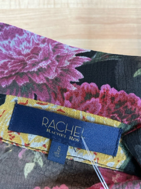 Close-up of Rachel Roy dress label on floral chiffon fabric, indicating size S/P and confirming authenticity of pre-owned designer wrap dress.