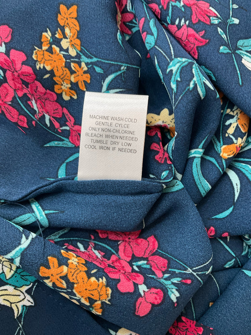 Care label of Daniel Rainn Floral Sleeveless Blouse Top Size Small with machine wash instructions and fabric care tips for long-lasting wear.