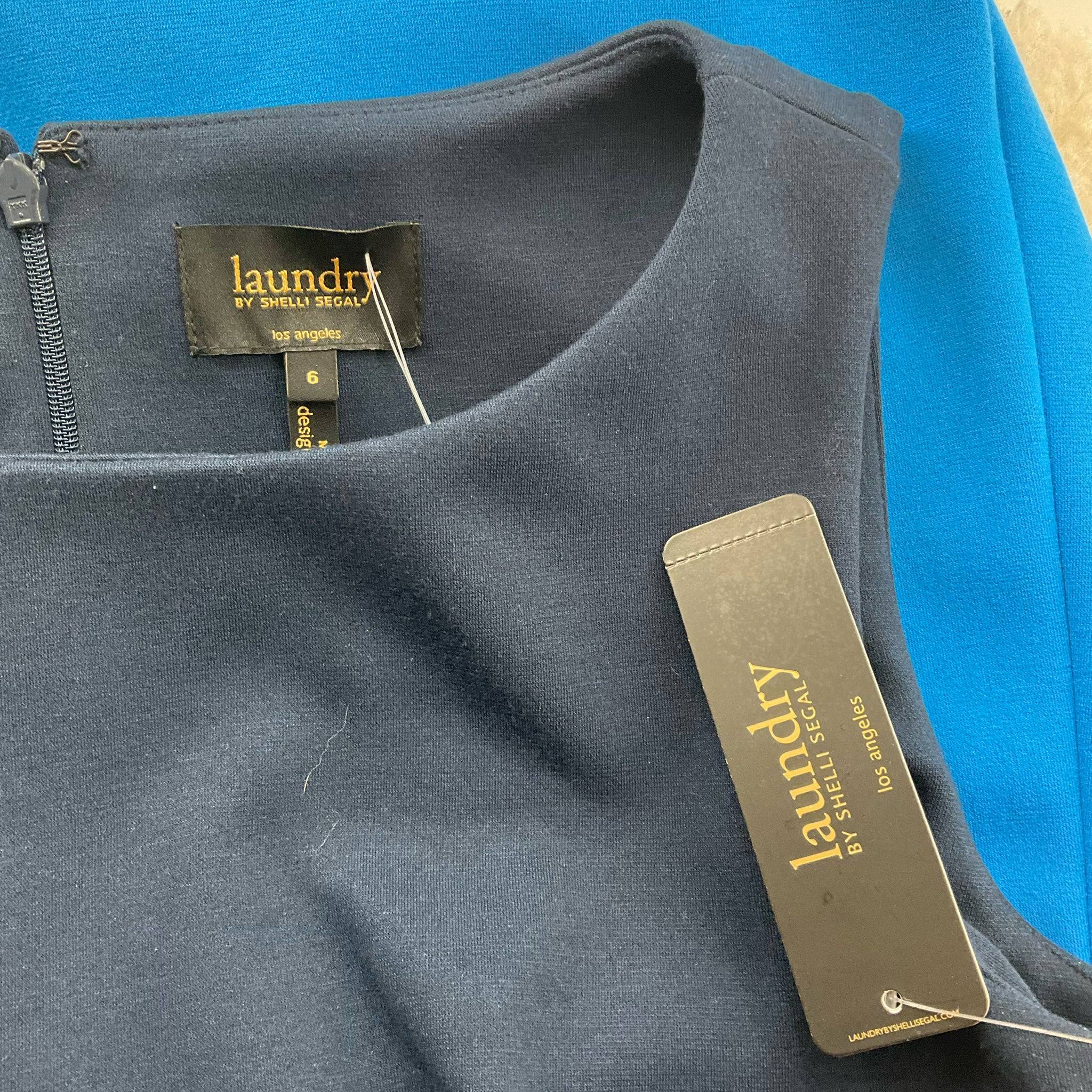 Close-up of Laundry by Shelli Segal brand tag and size label on new with tags dress, available at Margaret’s Fine Consignments.