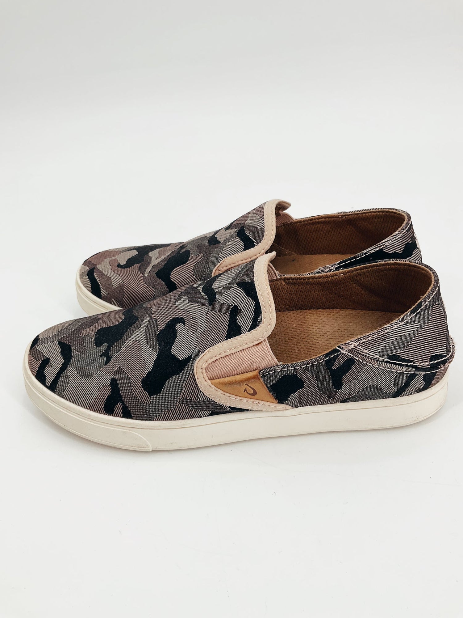 OluKai pink and black camo slip-on sneaker showcasing a casual, comfortable design in size 7/7.5.