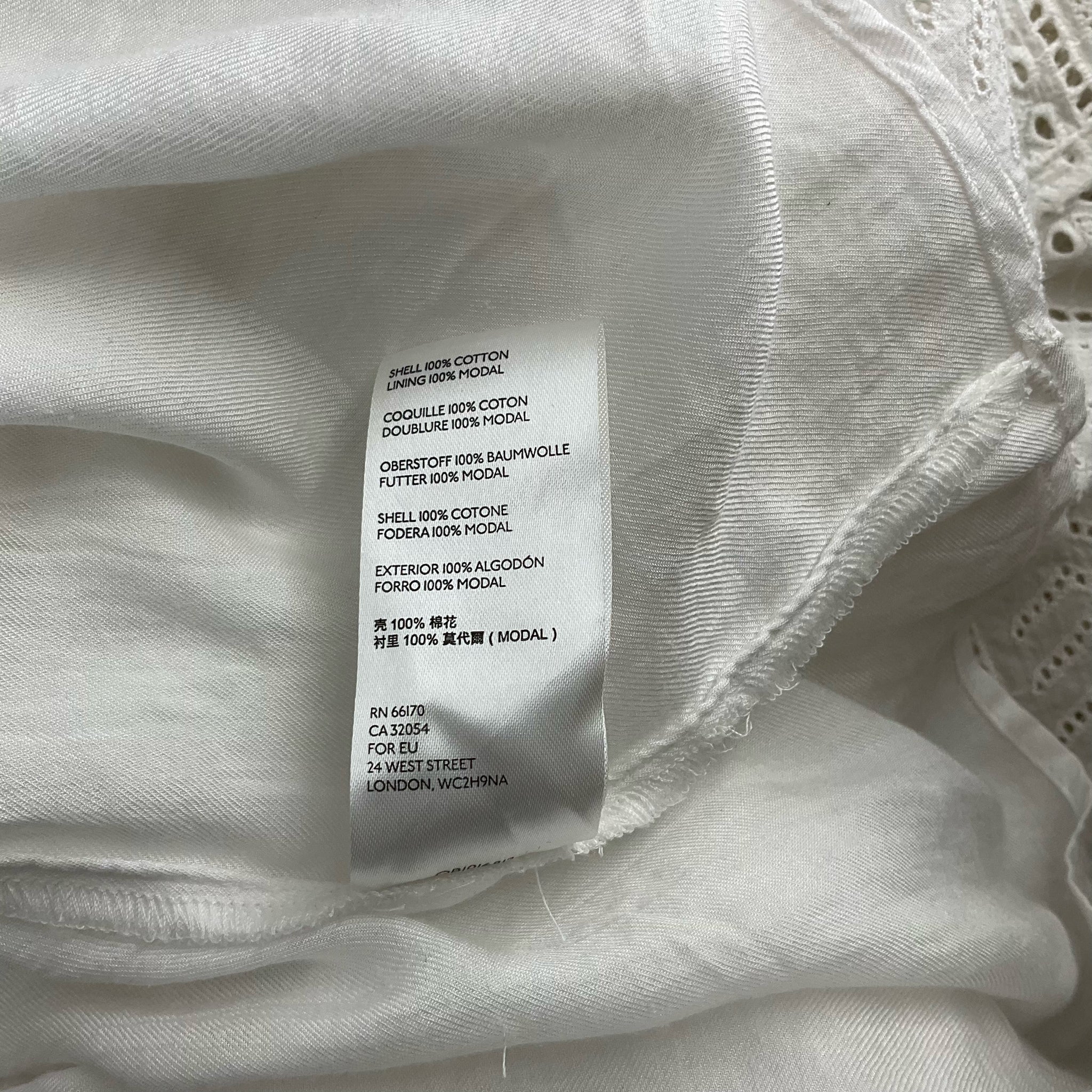 Fabric content label of Anthropologie White Solid Maxi Dress - Size 10 showing 100% cotton shell and 100% modal lining for breathable comfort.