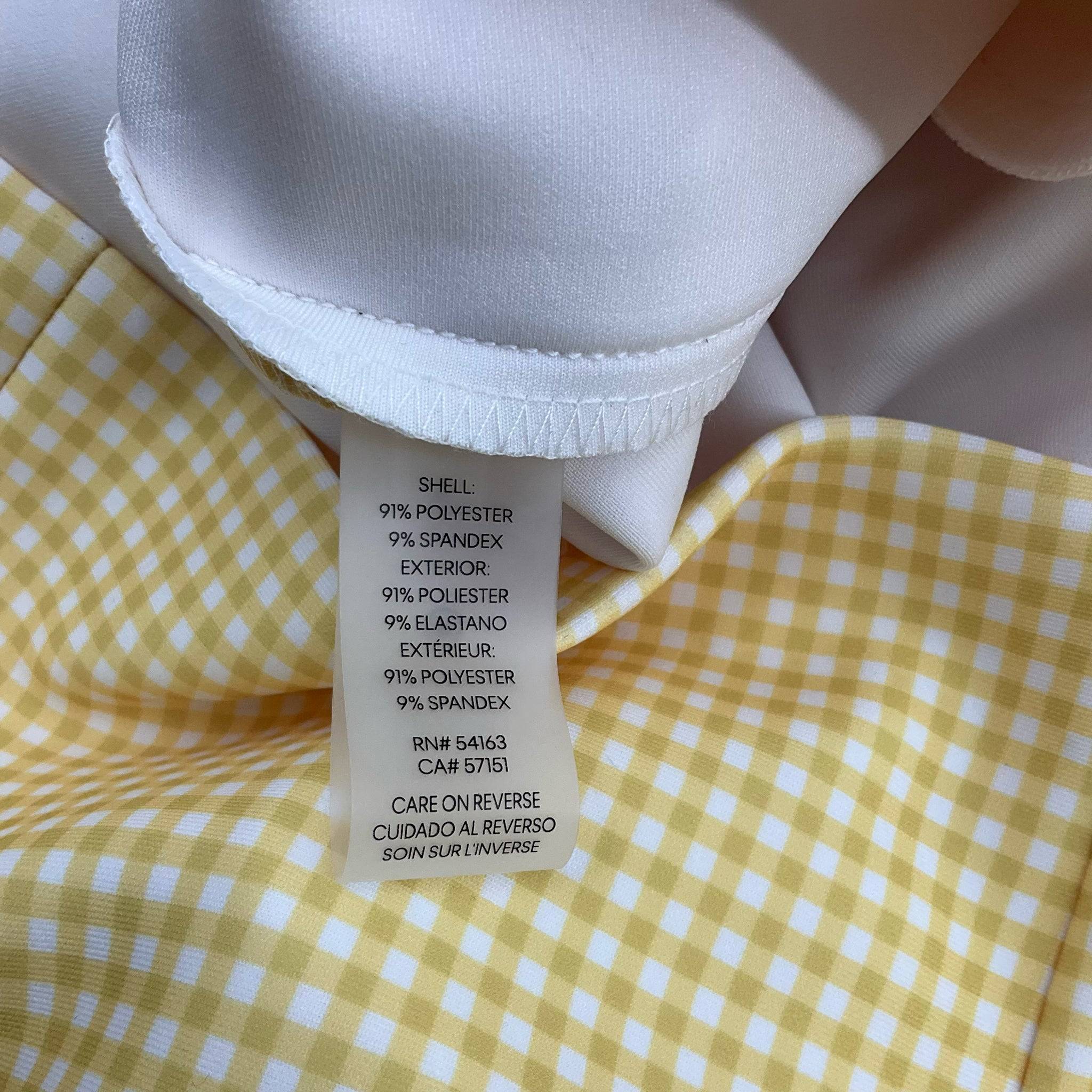 Close-up of fabric content tag showing polyester and spandex blend on Calvin Klein yellow and white checkered mini dress, size 12.