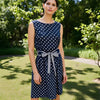 Jessica Howard sleeveless navy and white polka dot mini dress size 12, styled outdoors, available at Margaret’s Fine Consignments.