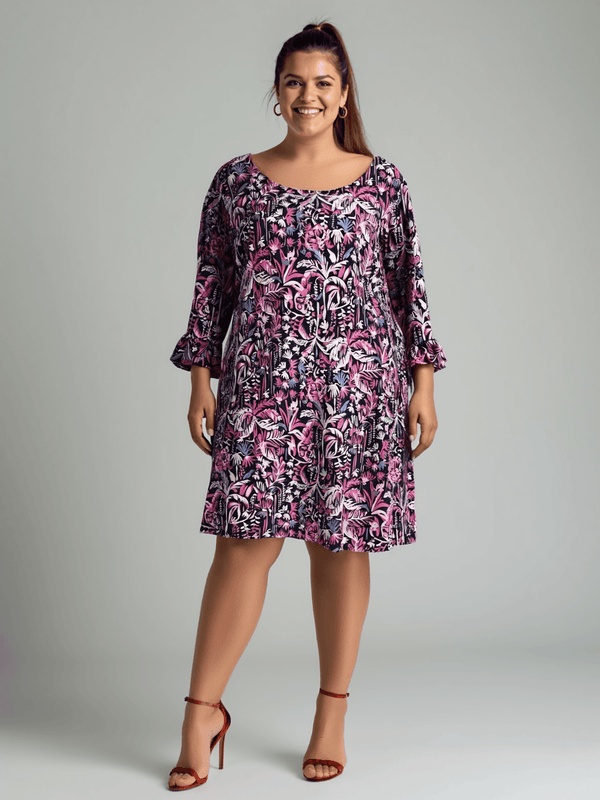 Lilly Pulitzer Dress Size XL in purple and pink palm print modeled with red heels, available at Margaret’s Fine Consignments.