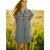 Woman wearing J Crew Print Mini Dress Size Medium in black and white checkered pattern, styled casually outdoors for Margaret’s Fine Consignments.