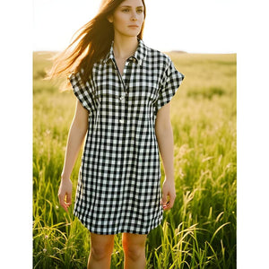 Woman wearing J Crew Print Mini Dress Size Medium in black and white checkered pattern, styled casually outdoors for Margaret’s Fine Consignments.