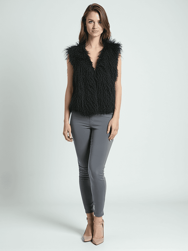 WD-NY Vest Size XL styled on model with sleek gray pants, available at Margaret’s Fine Consignments. Black faux fur design adds chic texture.