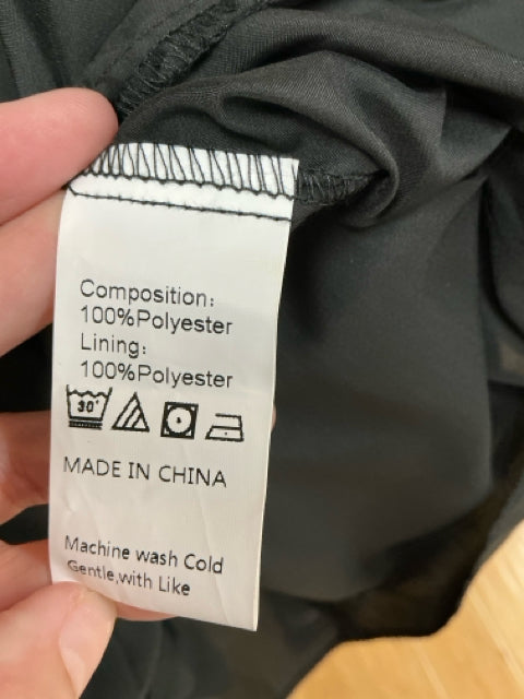 Close-up of fabric tag showing Anna Kaci dress composition as 100% polyester with care instructions, made in China.