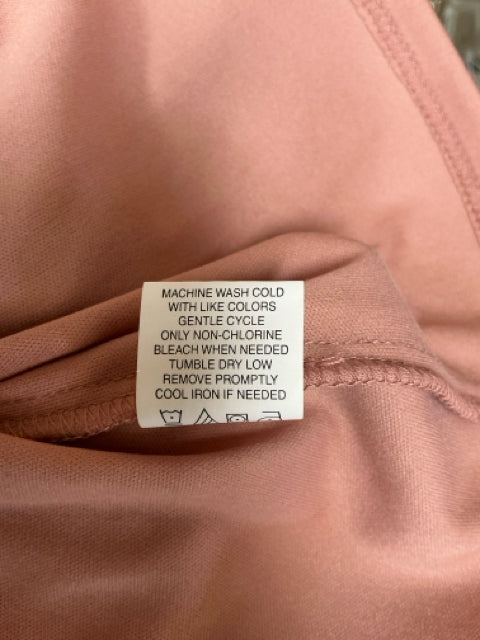 Care label on C. Wonder mauve lace dress indicating machine wash cold, gentle cycle, and tumble dry low instructions for easy maintenance.