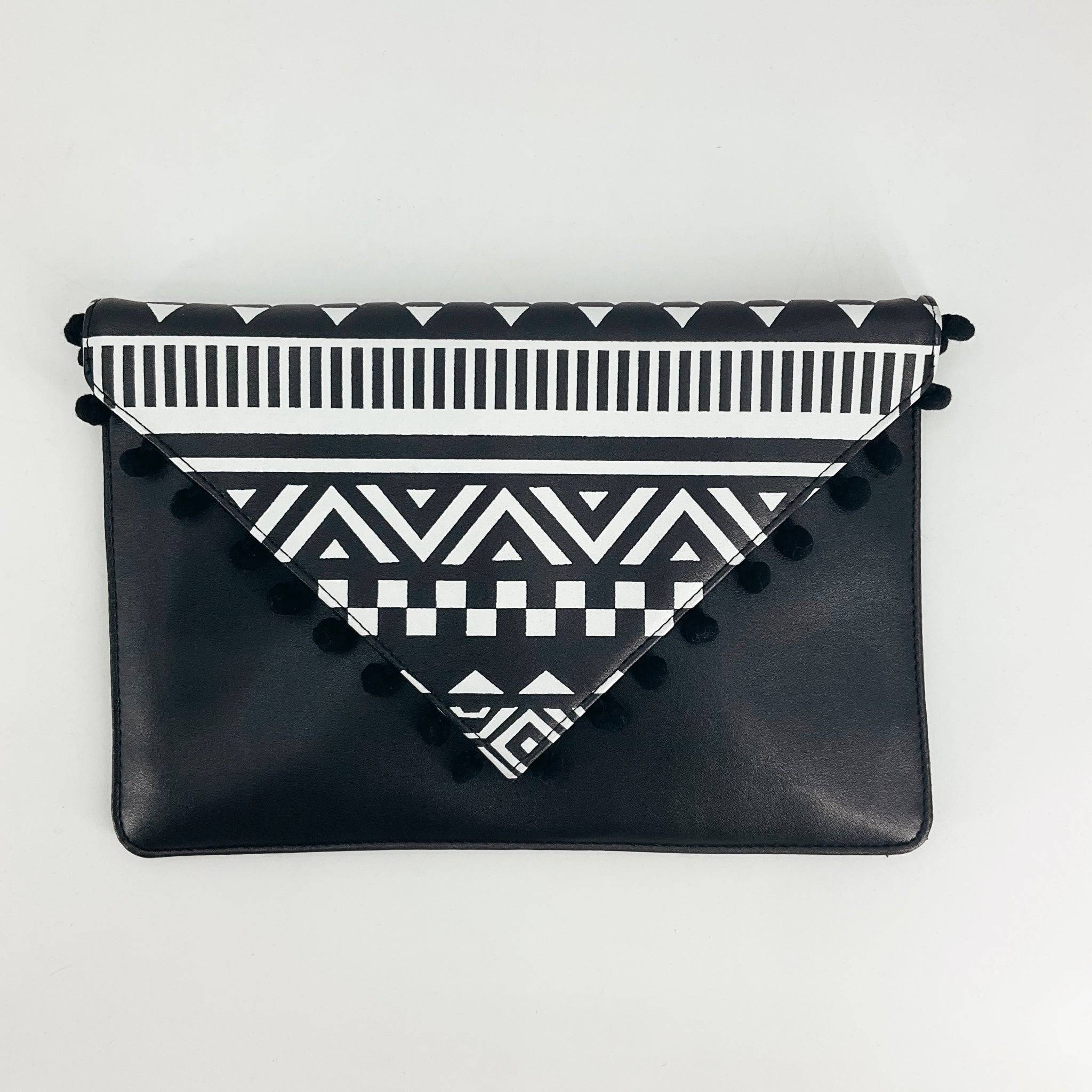 Sondra Roberts Black/White Print Purse with geometric tribal pattern and pom-pom trim, available at Margaret's Fine Consignments.