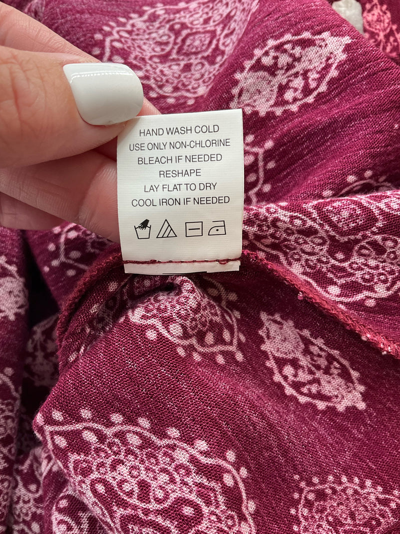 Care instruction tag on Luq maroon/pink tank top, detailing hand wash cold and lay flat to dry for rayon fabric maintenance.