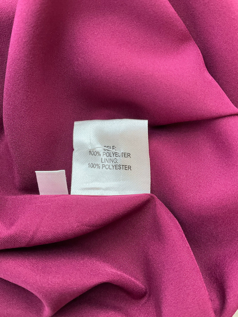 Fabric tag of Oleg Cassini plum dress showing 100% polyester shell and lining, ensuring lightweight comfort for weddings or professional wear.