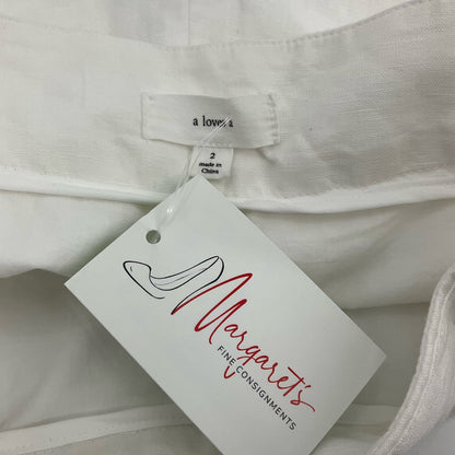 White high-waisted pleated shorts by a loves a, size 2, featuring cuffed hems, perfect for casual coastal wear.