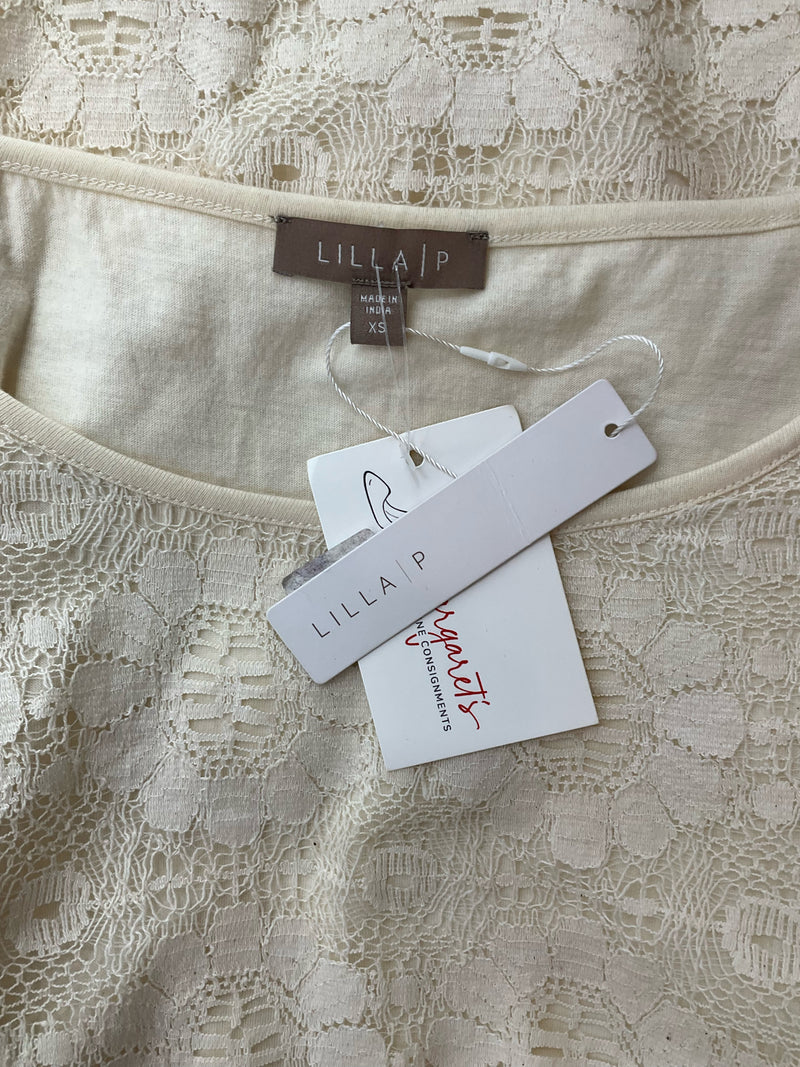 Close-up of Lilla P Cream Lace Top tags showing brand label and new with tags status. Size XS casual lace blouse for women.