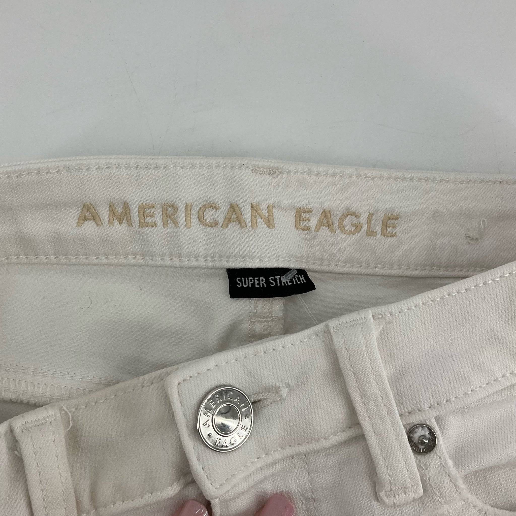 Close-up of american eagle branding and super stretch label on the inner waistband of Size 4 White ripped Shorts.