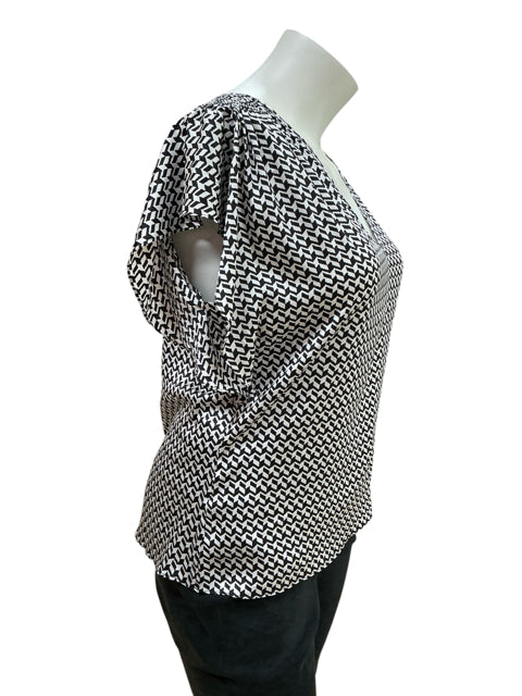 Side view of White House Black Market black/white print top, size XL. Features relaxed fit and draped sleeves for a flattering silhouette.