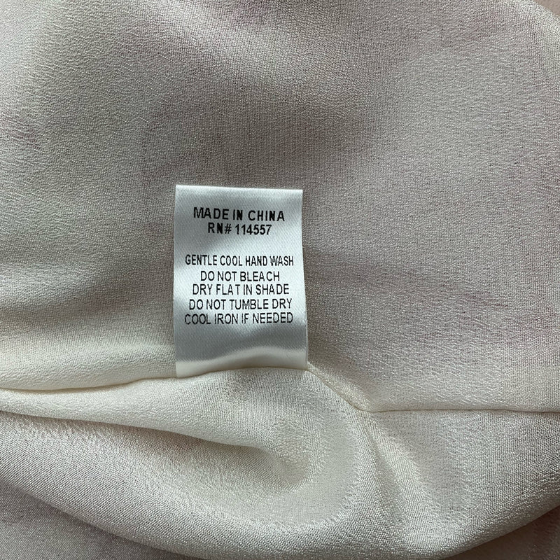 Care label of THML white/red floral dress, size large. Instructions include gentle hand wash and cool iron if needed.