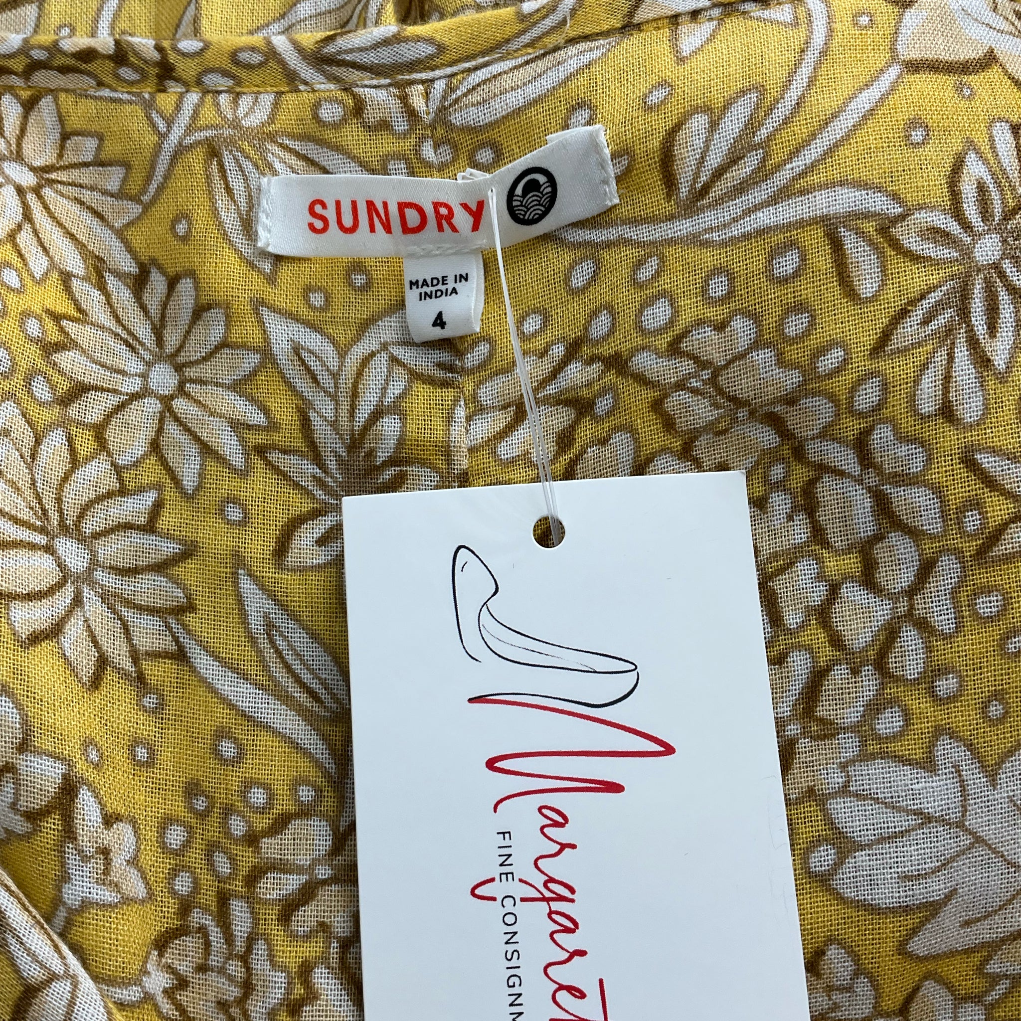 Close-up of Sundry brand label and size tag on Yellow/Tan Floral Dress - Size 4, confirming authenticity and pre-owned condition.