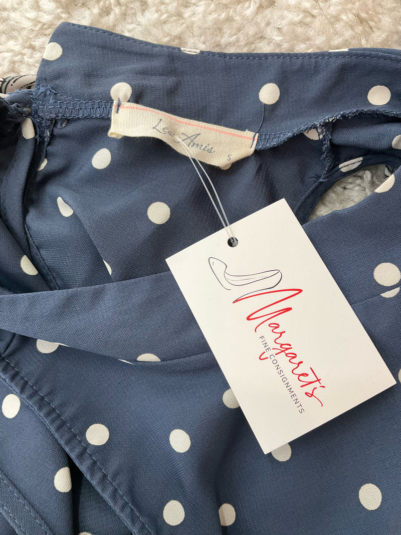 Close-up of Les Amis brand tag on blue polka dot blouse with attached Margaret’s Fine Consignments label, confirming pre-owned status.