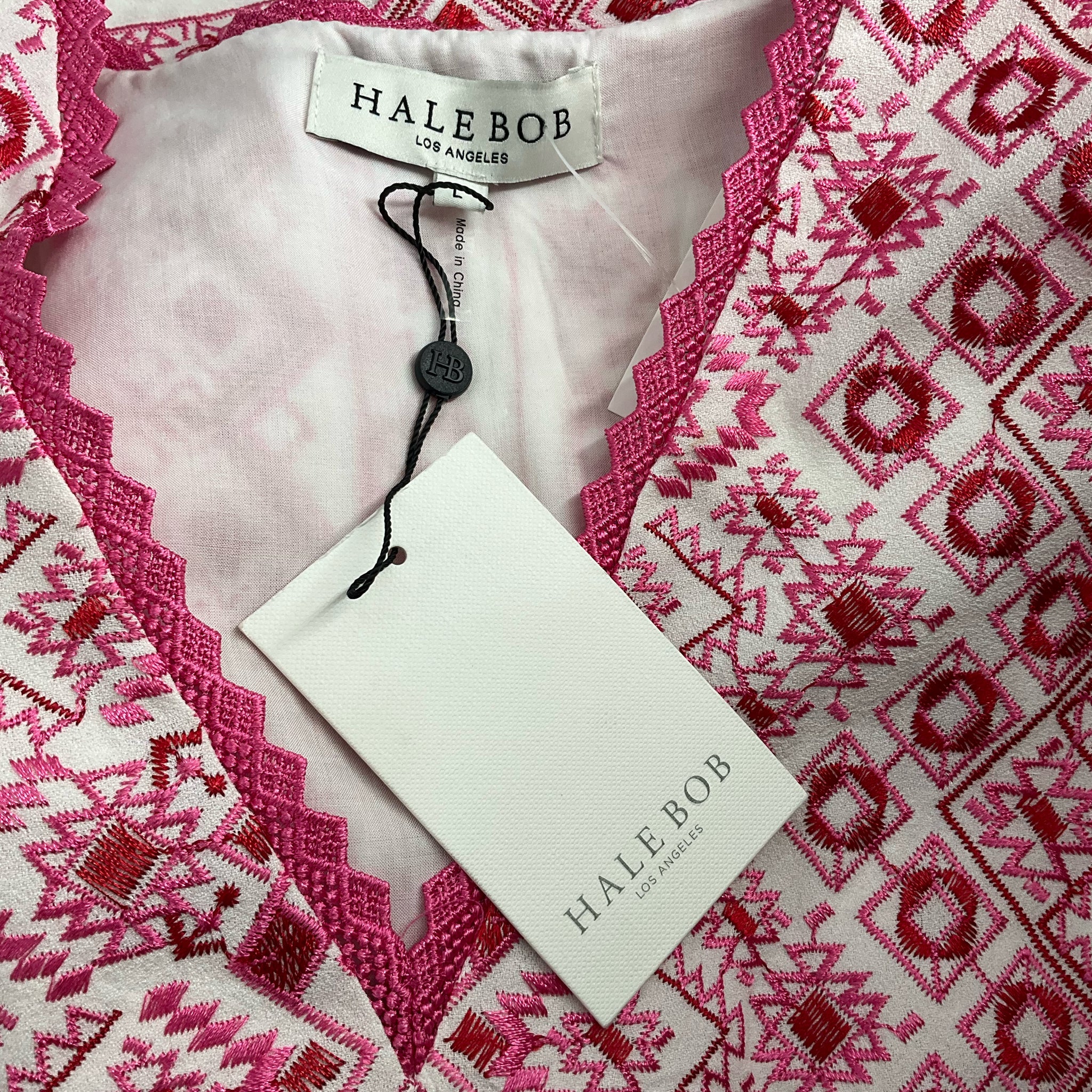 Close-up of Hale Bob dress neckline with pink embroidered trim and brand tag, confirming new with tags designer resort wear.