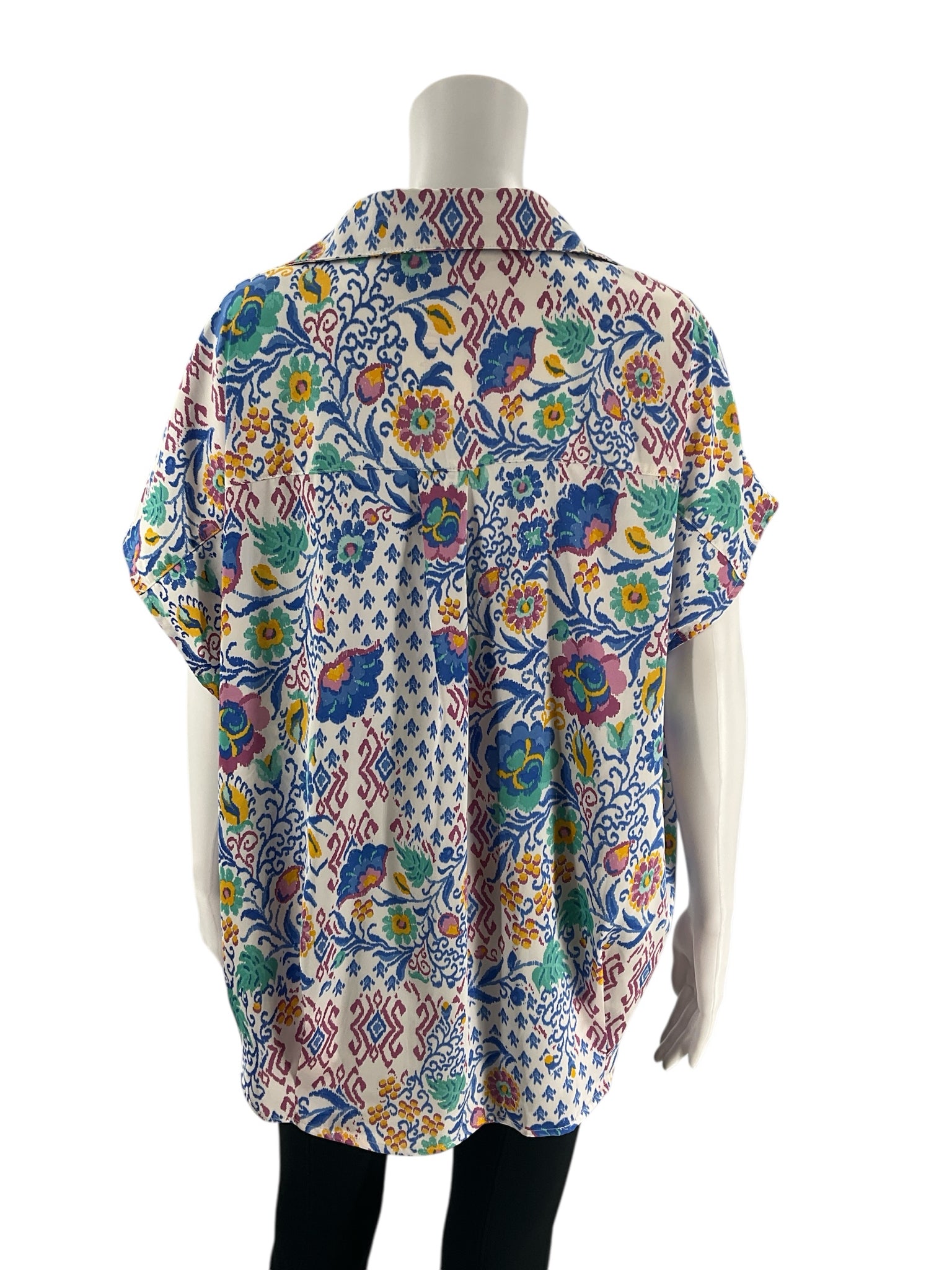Back view of Jodifl white/blue/purple floral top size medium featuring vibrant floral patterns and relaxed fit, pre-owned at Margaret's.