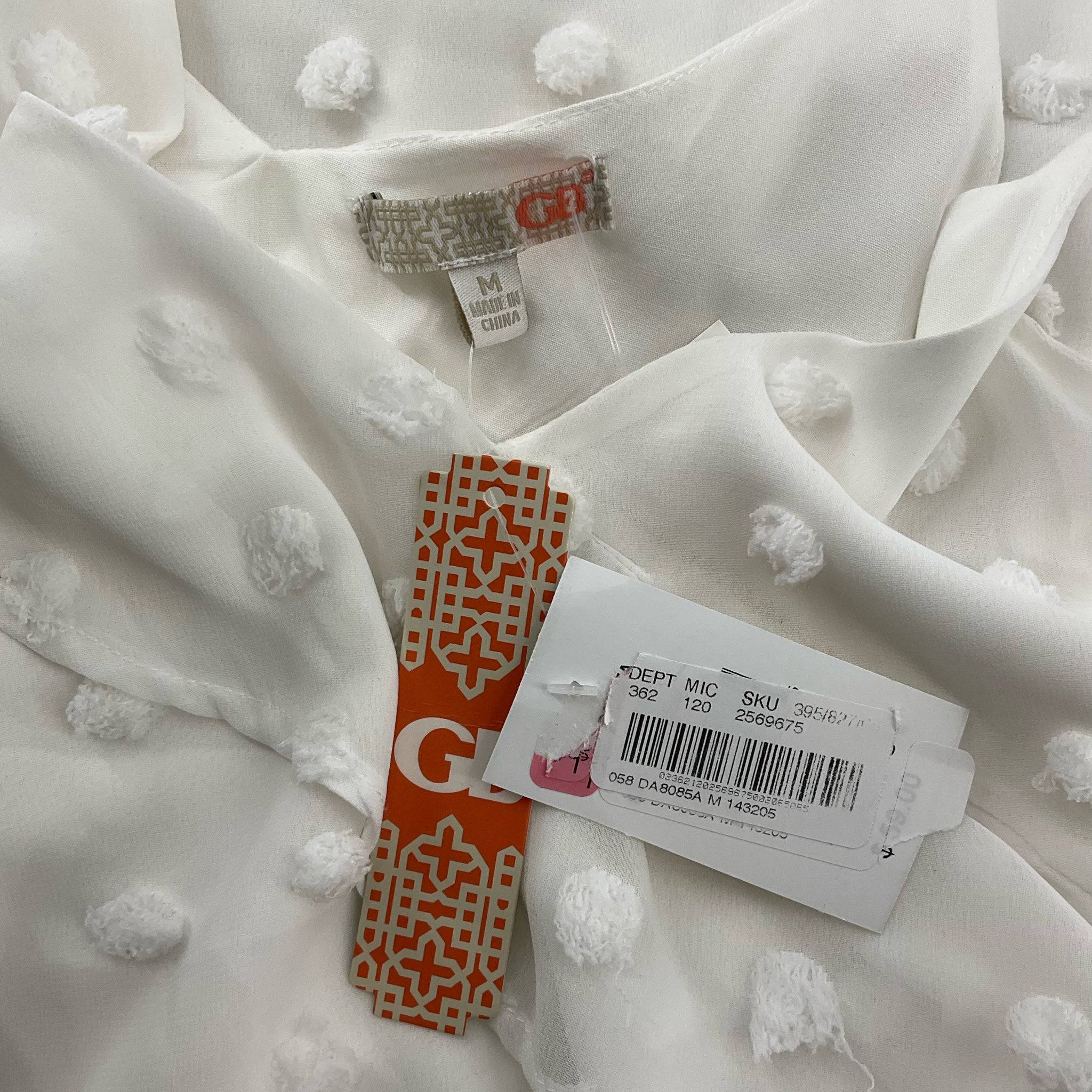 Close-up of GB dress label and retail tags confirming size Medium and SKU, indicating pre-owned but new with tags condition.