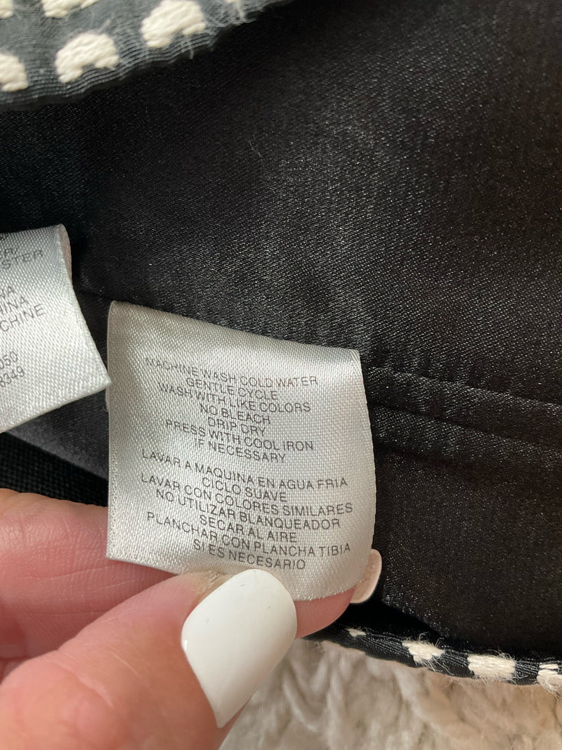 Care label of Rachel Roy heart jacquard mini dress with washing instructions in English and Spanish, suitable for delicate cold wash.