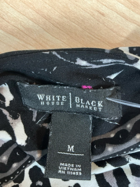 Brand label of White House Black Market dress with size M and RN 111359, confirming authenticity of pre-owned floral surplice dress.