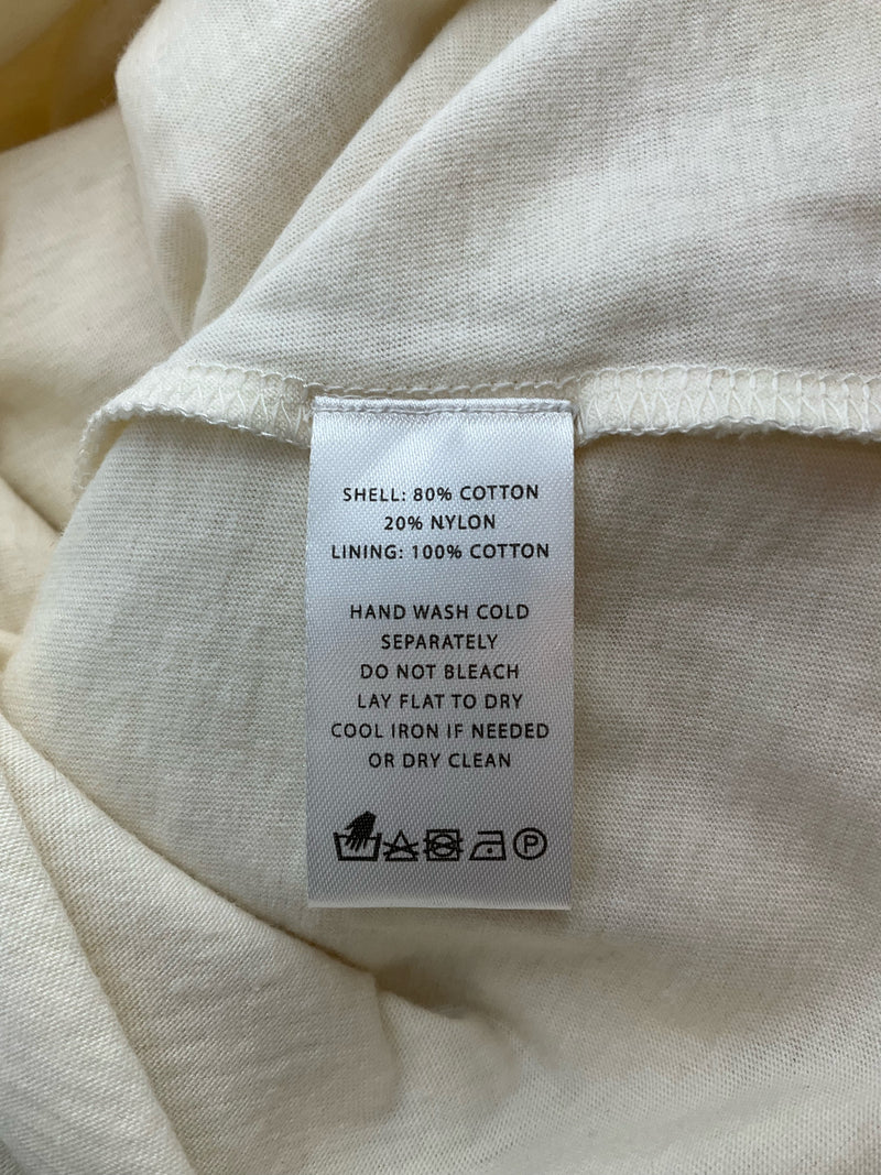 Fabric care label of Lilla P Cream Lace Pre-Owned Ladies Top - Size XS, detailing cotton-nylon blend and washing instructions. NWT apparel.