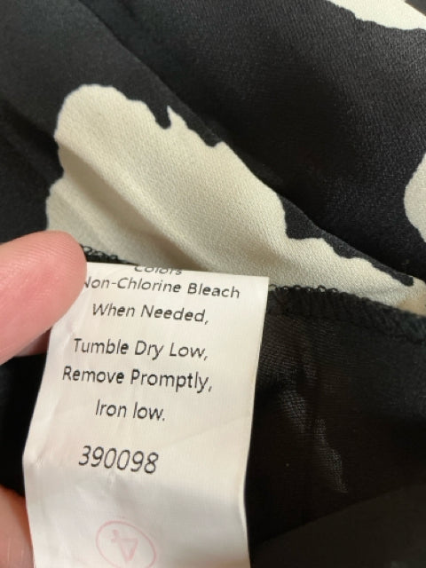 Detailed care label from Anna Kaci black/cream print dress indicating tumble dry low and iron low instructions.