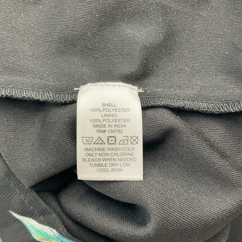 Fabric care label of Indulge Leaf Print Pre-Owned Romper - Size 1X showing 100% polyester material and washing instructions for garment care.