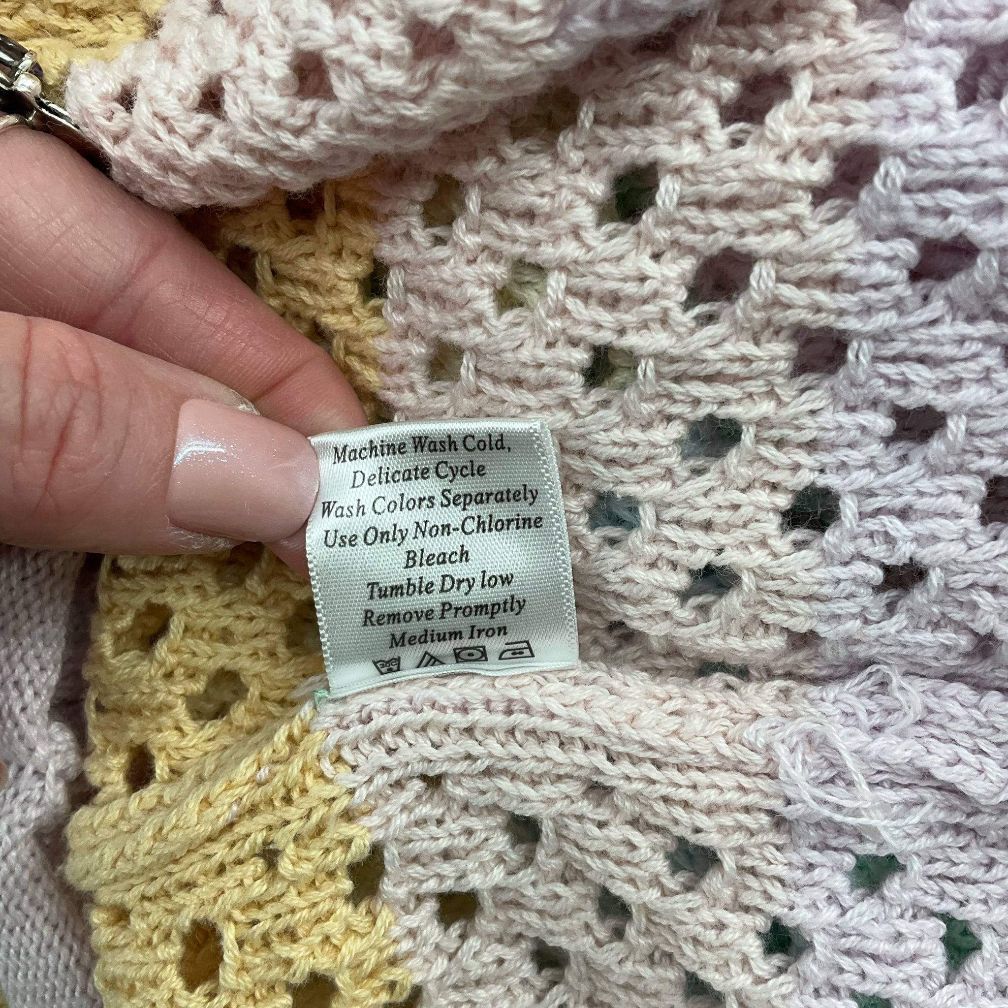 Care label for Pink Lily pastel rainbow sweater, size small, with washing and drying instructions for delicate fabric.