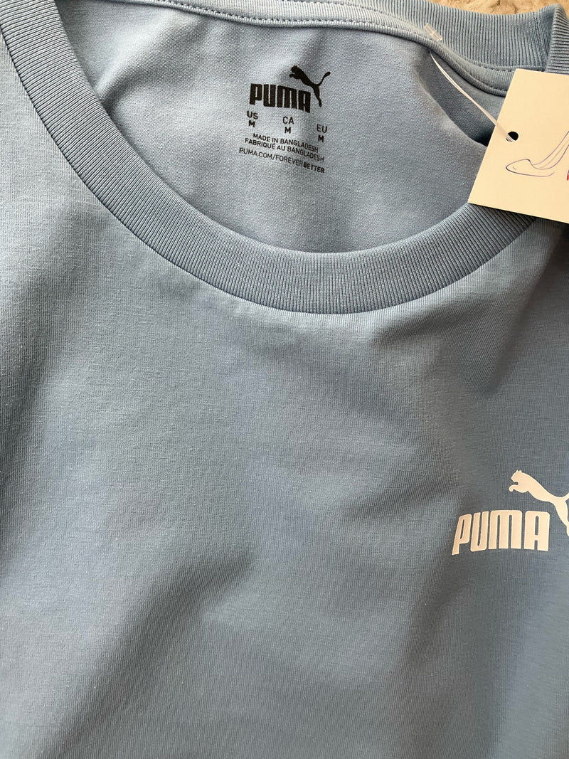 Close-up of Puma Essentials tank dress neckline and logo print on chest, showcasing soft cotton blend and brand detailing.