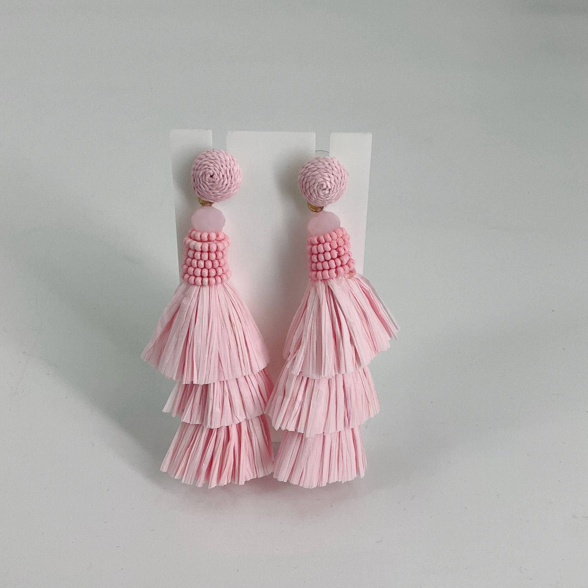 Pink tassel earrings with layered fringe design and beaded tops, perfect for adding a playful touch to casual or party outfits.