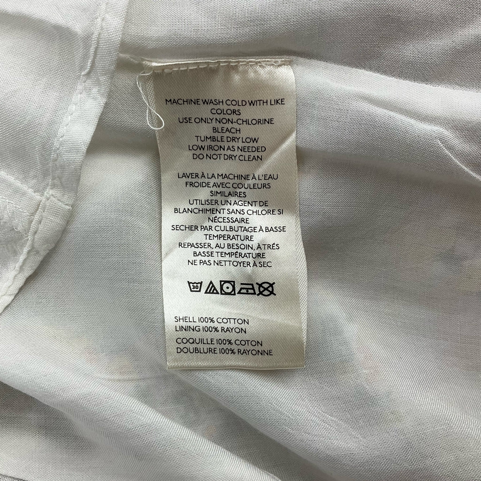 Fabric care label of Anthropologie Cream/Yellow/Orange Floral Dress - Size 10, made of 100% cotton shell and rayon lining.