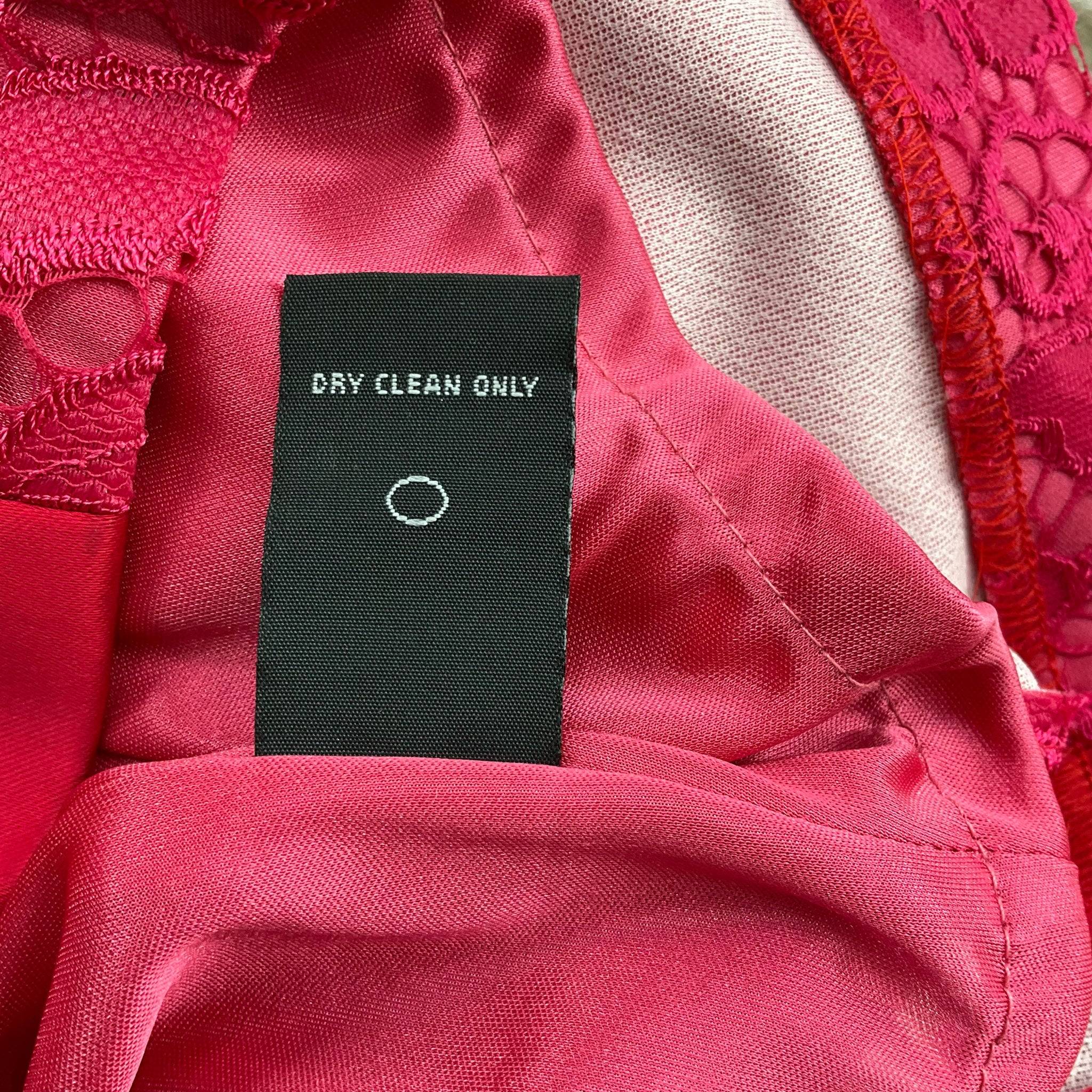Dry clean only care label on Jax V Neck Mini Dress Size 8 in pink lace, available at Margaret’s Fine Consignments. Proper garment care instructions.