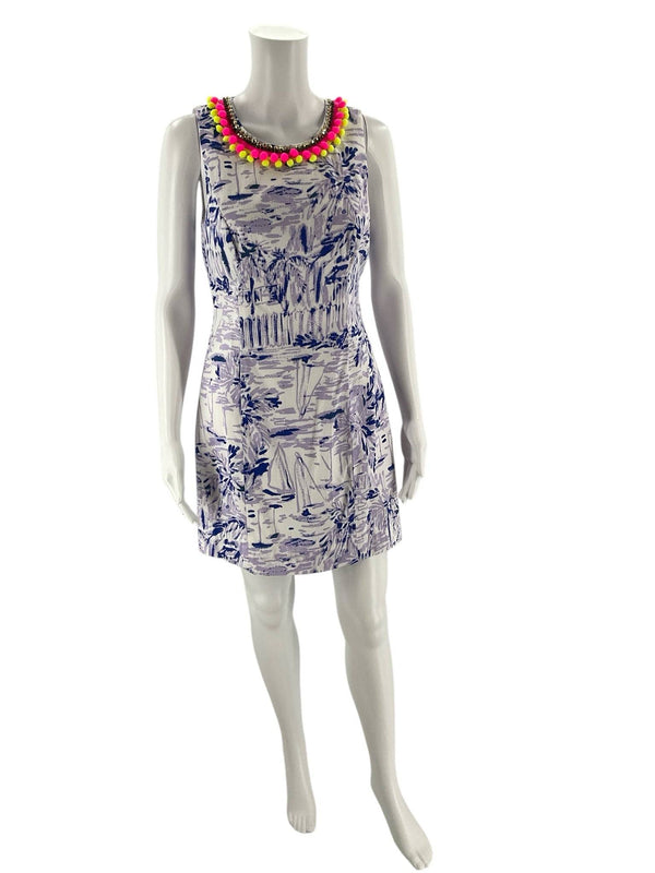 Front view of Lilly Pulitzer White & Purple Print Dress – Size 4 on mannequin, featuring sleeveless cut, fitted waist, and colorful pom-pom trim.