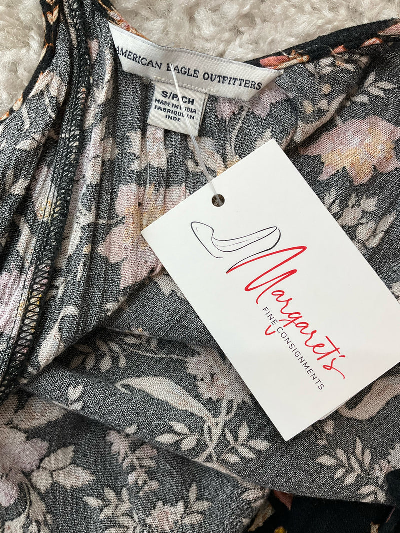 Close-up of American Eagle Outfitters label and attached resale tag on black floral cami top, confirming pre-owned condition and size small.
