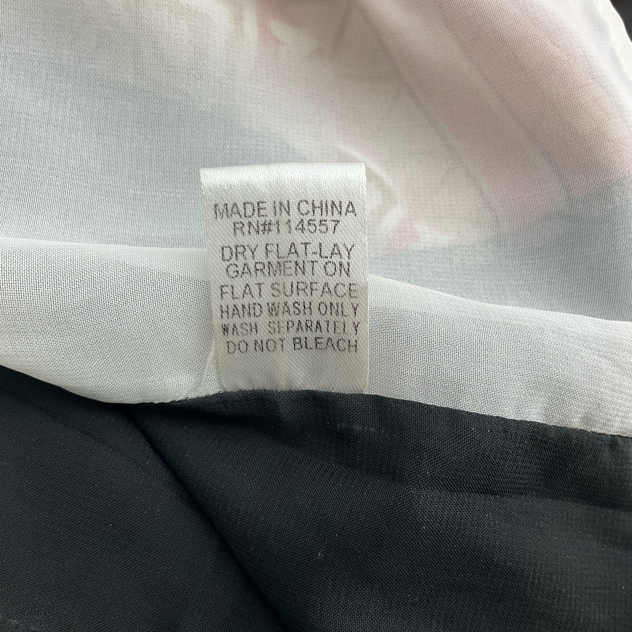 Care label on THML Coral/Multi Aztec Dress Size XS with washing instructions including hand wash only and dry flat.