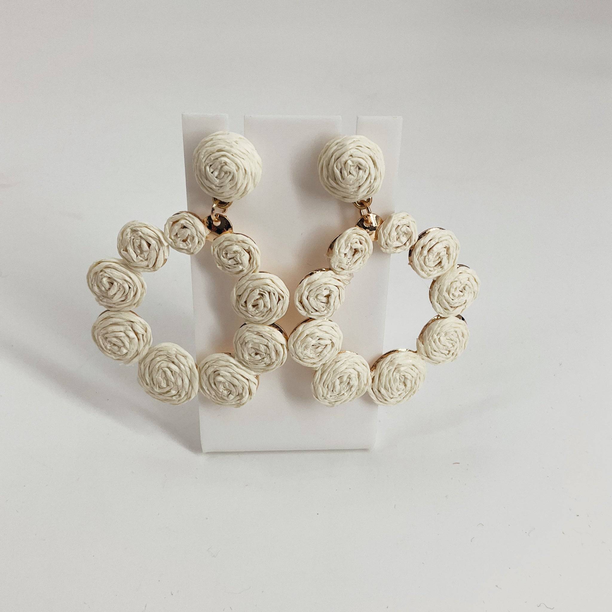 Handcrafted circular hoop earrings with white woven rose detailing, perfect for boho or summer fashion. Earrings from category: Earrings, Item ID: 650069.