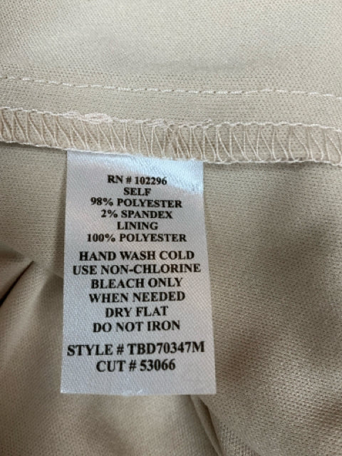 Close-up of fabric care label on Connected Apparel gold lace dress, detailing polyester-spandex blend and care instructions.