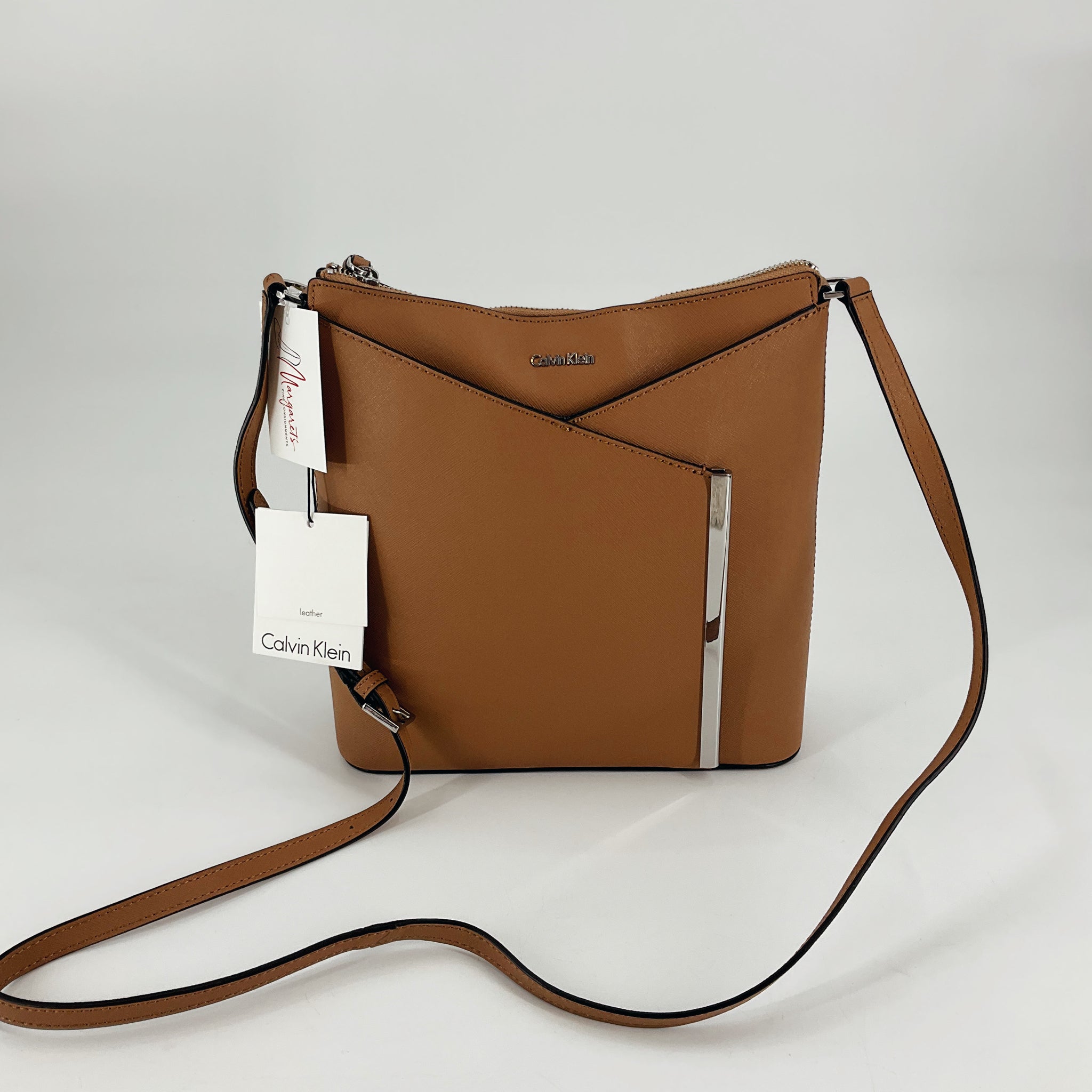 Calvin Klein Tan Solid Purse with sleek crossbody strap and silver-tone accents, NWT, ideal for everyday fashion and functionality.